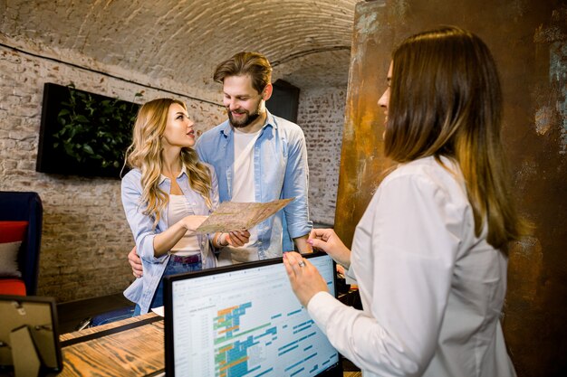 female receptionist giving tourist information happy young couple holding city map standing hotel reception 161094 2550